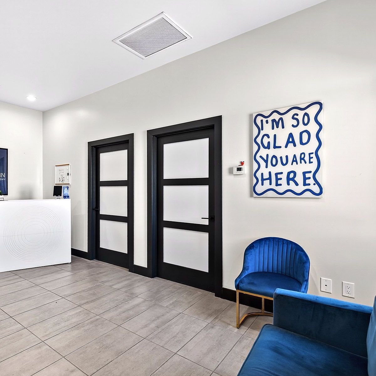 The reception area at Goodwin Learning Academy, with a hand-lettered sign reading I'm so glad you are here